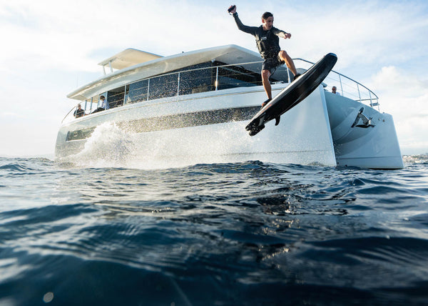 A man makes a jump on the ravik S in front of a yacht.